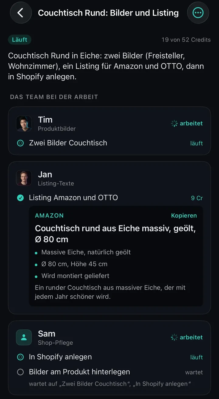 The Office auf dem iPhone, Auftrag „Couchtisch Rund: Bilder und Listing“, läuft, 19 von 52 Credits. Darunter der Auftragstext „Couchtisch Rund in Eiche: zwei Bilder (Freisteller, Wohnzimmer), ein Listing für Amazon und OTTO, dann in Shopify anlegen.“ Tim (Produktbilder) arbeitet an „Zwei Bilder Couchtisch“. Jans Aufgabe „Listing Amazon und OTTO“ ist fertig, darunter die Amazon-Fassung mit dem Titel „Couchtisch rund aus Eiche massiv, geölt, Ø 80 cm“ und drei Stichpunkten. Sam (Shop-Pflege) legt das Produkt in Shopify an; „Bilder am Produkt hinterlegen“ wartet auf die Bilder und das angelegte Produkt.